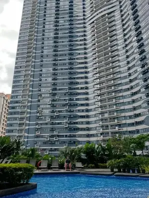 a large building with a swimming pool in front of it at Air Residence Makati in Manila