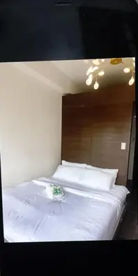 a large white bed with a wooden head board at Air Residence Makati in Manila