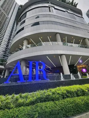 a large building with a blue sign in front of it at Air Residence Makati in Manila
