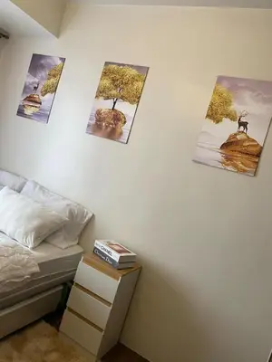 a bedroom with four pictures on the wall at Air Residence Makati in Manila
