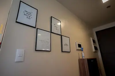 a wall with four framed pictures on a wall at Elegant unit, fast wifi, near Makati Medical Centr in Manila