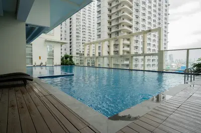 a large swimming pool in a building with tall buildings at Elegant unit, fast wifi, near Makati Medical Centr in Manila