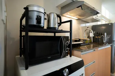 a microwave on a shelf in a kitchen at Elegant unit, fast wifi, near Makati Medical Centr in Manila