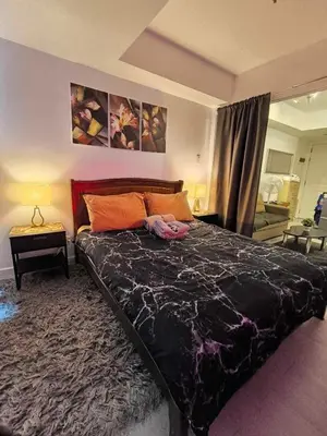 a bedroom with a large bed with a black comforter at Azure Staycation by Zette in Manila