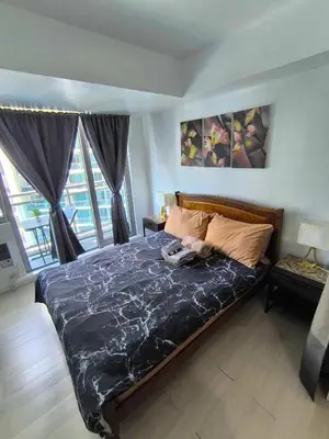 a bedroom with a bed with a dog laying on it at Azure Staycation by Zette in Manila