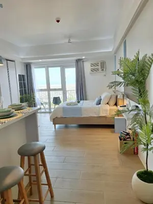 a bedroom with a bed and a table and chairs at Luxury Coastal Suite, Grand Canal view in Manila