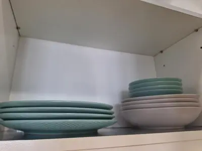 three plates and bowls are sitting on a shelf at Luxury Coastal Suite, Grand Canal view in Manila