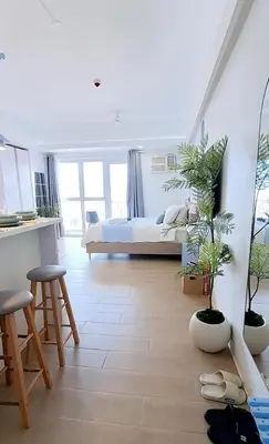 a bedroom with a bed and two potted plants at Luxury Coastal Suite, Grand Canal view in Manila