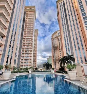 a large swimming pool in a city with tall buildings at Luxury Coastal Suite, Grand Canal view in Manila