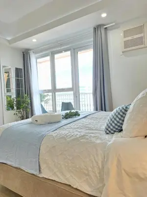 a bedroom with a large bed with a large window at Luxury Coastal Suite, Grand Canal view in Manila