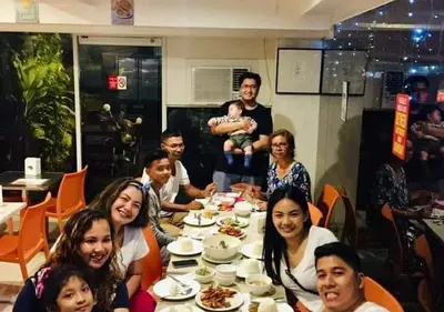 a group of people sitting around a table eating at Stone House Hotel Pasay in Manila