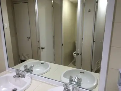 a bathroom with two sinks and a large mirror at Stone House Hotel Pasay in Manila