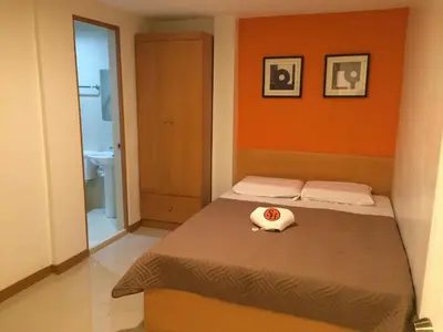 a small bedroom with a bed and a bathroom at Stone House Hotel Pasay in Manila