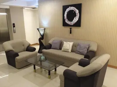 a living room with a couch and two chairs and a table at Stone House Hotel Pasay in Manila