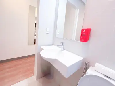 a white bathroom with a sink and a toilet at Red Planet Makati Amorsolo in Manila
