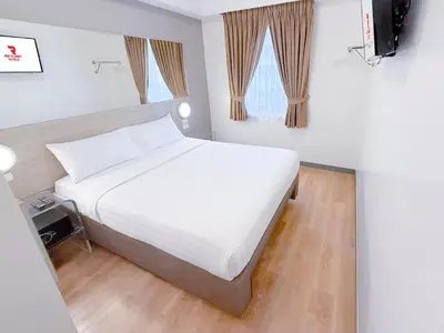 a bedroom with a large white bed and a window at Red Planet Makati Amorsolo in Manila