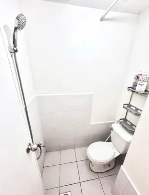 a small bathroom with a toilet and a shower at Jam Reid Condotel Mandaluyong in Manila
