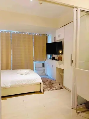 a bedroom with a bed and a desk and a television at Upscale 1Bedroom Condo Unit Near Manila Airport in Manila