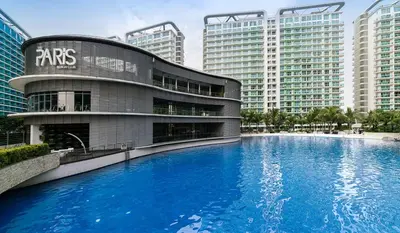 a building with a large swimming pool in front of it at Upscale 1Bedroom Condo Unit Near Manila Airport in Manila