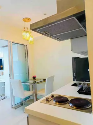 a kitchen with a table with chairs and a stove at Upscale 1Bedroom Condo Unit Near Manila Airport in Manila