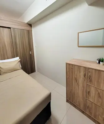 a bedroom with a bed and a wooden cabinet at An-Dy's Point, Field Residences in Manila