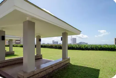 a white pavilion with green grass and a city at SMDC Light Residences Condominium in Manila