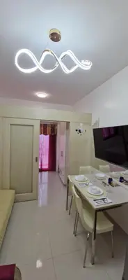 a dining room with a table and chairs and a chandelier at SMDC Light Residences Condominium in Manila