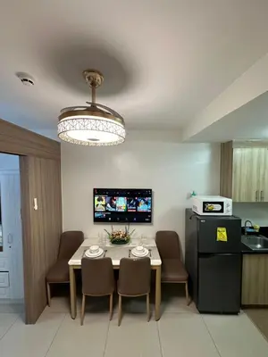 a kitchen and dining room with a table and chairs at Mall of Asia Vermilion Grand Suite in Manila