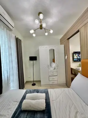 a bedroom with a bed with a dresser and a mirror at Mall of Asia Vermilion Grand Suite in Manila