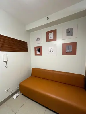 a couch in a room with pictures on the wall at Mall of Asia Vermilion Grand Suite in Manila