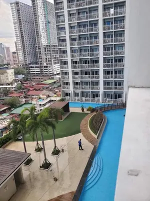 a person standing in front of a large building at La Luz 0835 Smdc Breeze in Manila