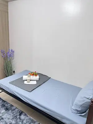 a bed with a blue sheet and flowers on it at Unistay SHORE Residence amazing pool view in Manila