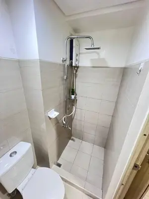 a bathroom with a toilet and a shower at Unistay SHORE Residence amazing pool view in Manila