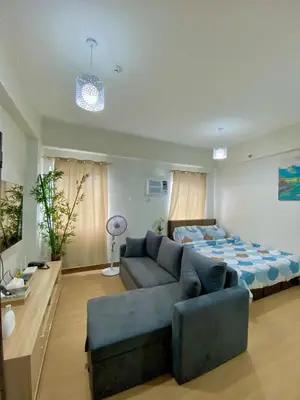a living room with a couch and a bed at Casa Maria Staycation SMDC Hope Residences in Trece Martires