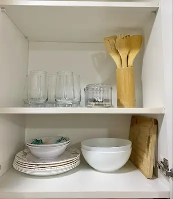 a white cabinet with bowls and plates and utensils at Casa Maria Staycation SMDC Hope Residences in Trece Martires