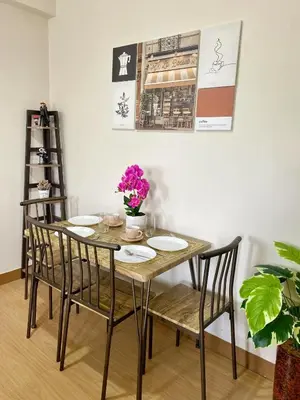 a dining room table and chairs with flowers on it at Casa Maria Staycation SMDC Hope Residences in Trece Martires