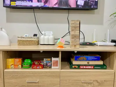 a wooden shelf with books and a tv on top at Casa Maria Staycation SMDC Hope Residences in Trece Martires