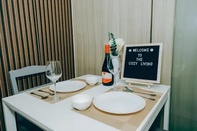 a table with plates and wine glasses and a computer on it at MOA city view in Manila