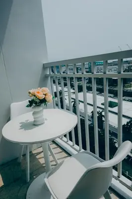 a white table with a vase of flowers on a balcony at MOA city view in Manila