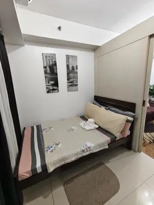 a small bed in a room with two pictures on the wall at Sea Residence MOA - JULIZA STAYCATION in Manila