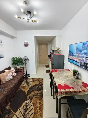 a living room with a couch and a table at Sea Residence MOA - JULIZA STAYCATION in Manila