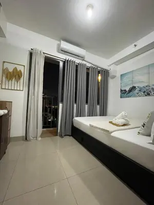 a bedroom with a large bed and a window at 12 Minutes from Mall of Asia - Spacious Condo with Balcony & Hot Shower in Manila