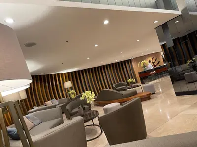 a lobby with couches and chairs and a piano at 12 Minutes from Mall of Asia - Spacious Condo with Balcony & Hot Shower in Manila