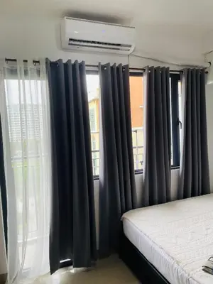 a bedroom with black curtains in front of a window at 12 Minutes from Mall of Asia - Spacious Condo with Balcony & Hot Shower in Manila