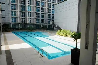 a large swimming pool in the middle of a building at Beautiful 1-Bedroom Condo in Makati - Pool, Gym & Near Airport in Manila