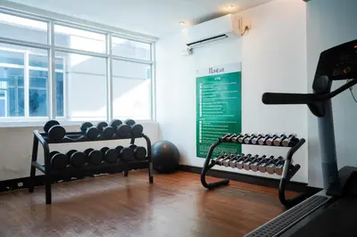 a room with a gym with a lot of weights at Beautiful 1-Bedroom Condo in Makati - Pool, Gym & Near Airport in Manila