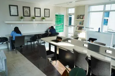 two people sitting in a room with tables and chairs at Beautiful 1-Bedroom Condo in Makati - Pool, Gym & Near Airport in Manila