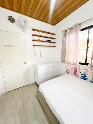 a bedroom with a white bed and a window at Eco's Place GenTri - Family Bungalow in General Trias