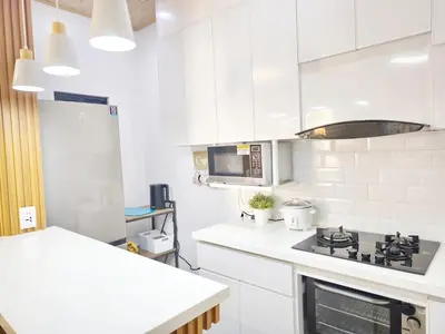 a white kitchen with a stove and a microwave at Eco's Place GenTri - Family Bungalow in General Trias