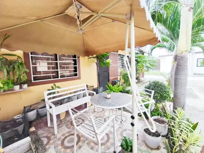 a patio with a table and chairs and an umbrella at Eco's Place GenTri - Family Bungalow in General Trias